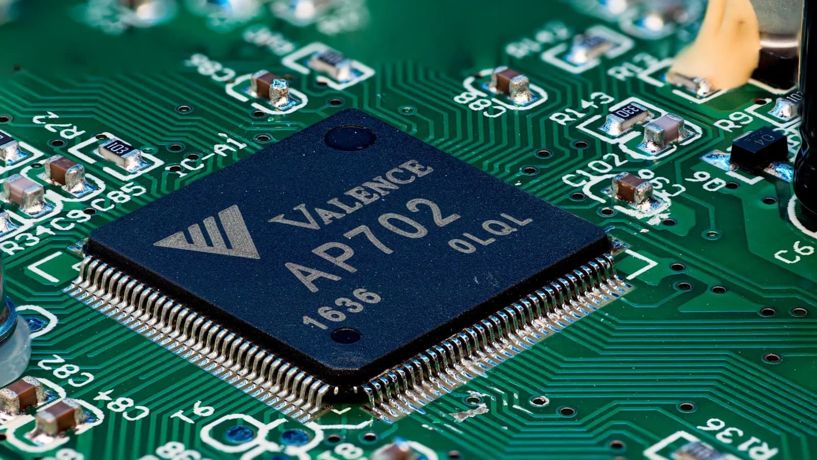 Sötétkék processzor egy zöld nyomtatott áramköri lapon.